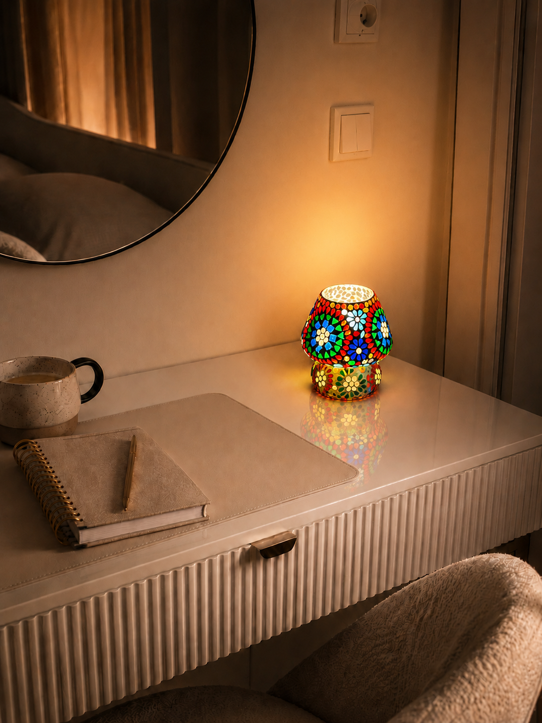 Kleine handgefertigte Rainbow-Mosaiklampe in Pilzform auf einem Schminktisch mit warmem Licht.
